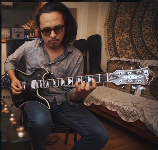 Sanjit with sunglasses and guitar